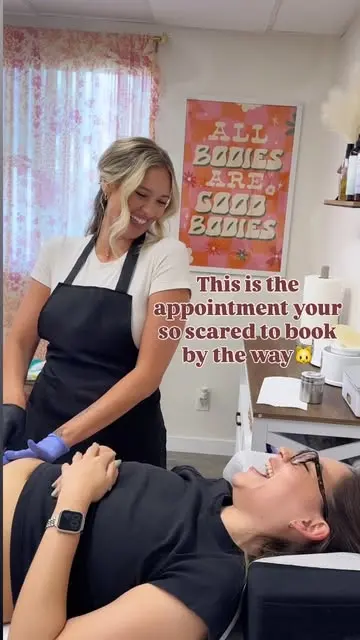 Lindsey sugaring a client under the All Bodies Are Good Bodies poster