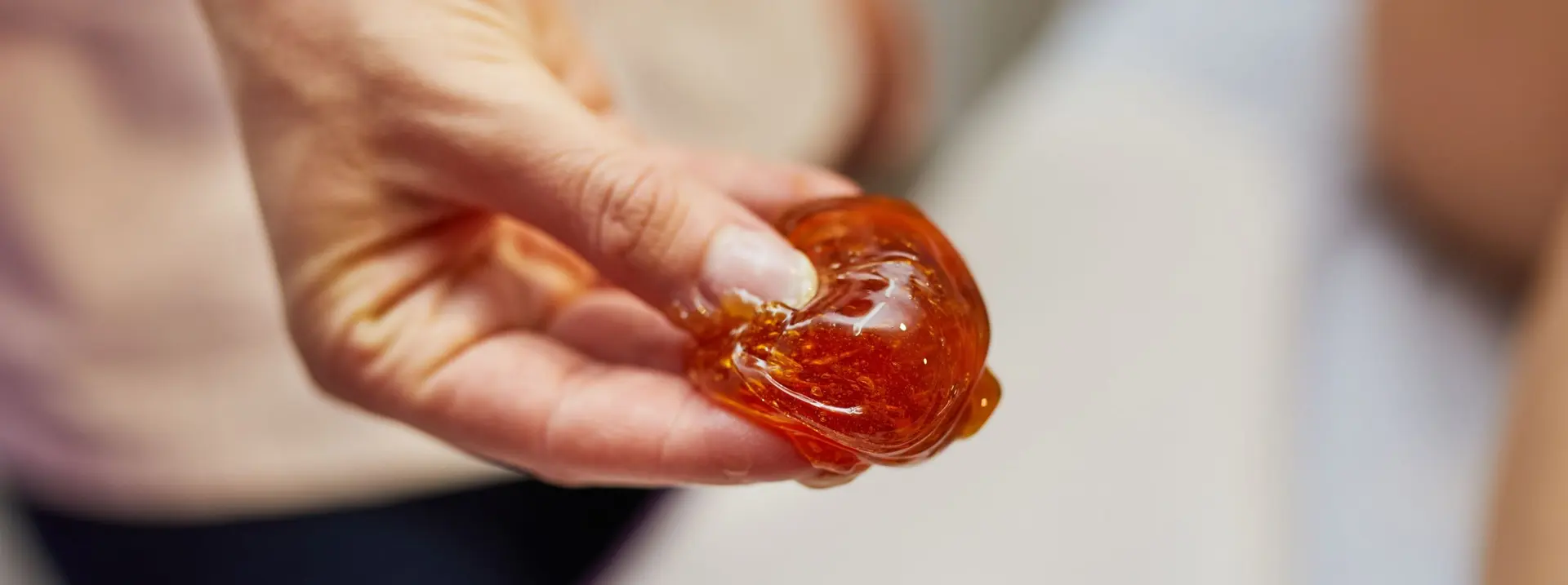 Hand holding a ball of warm organic sugar paste