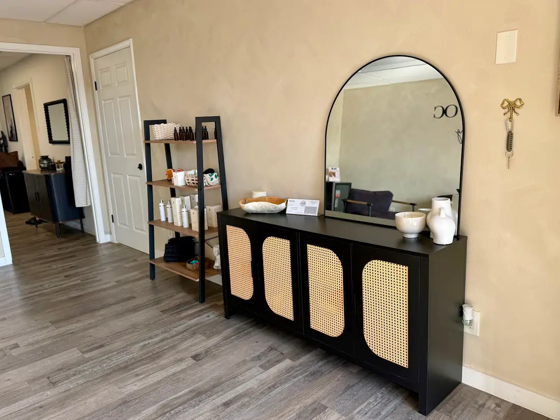 Sugar Bare OC lobby with an arched mirror and product shelf