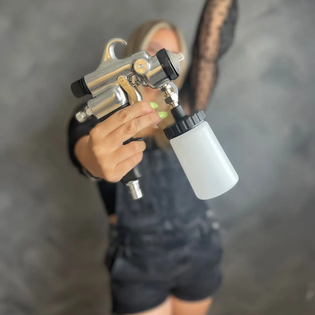 Lindsey holding a spray tan gun