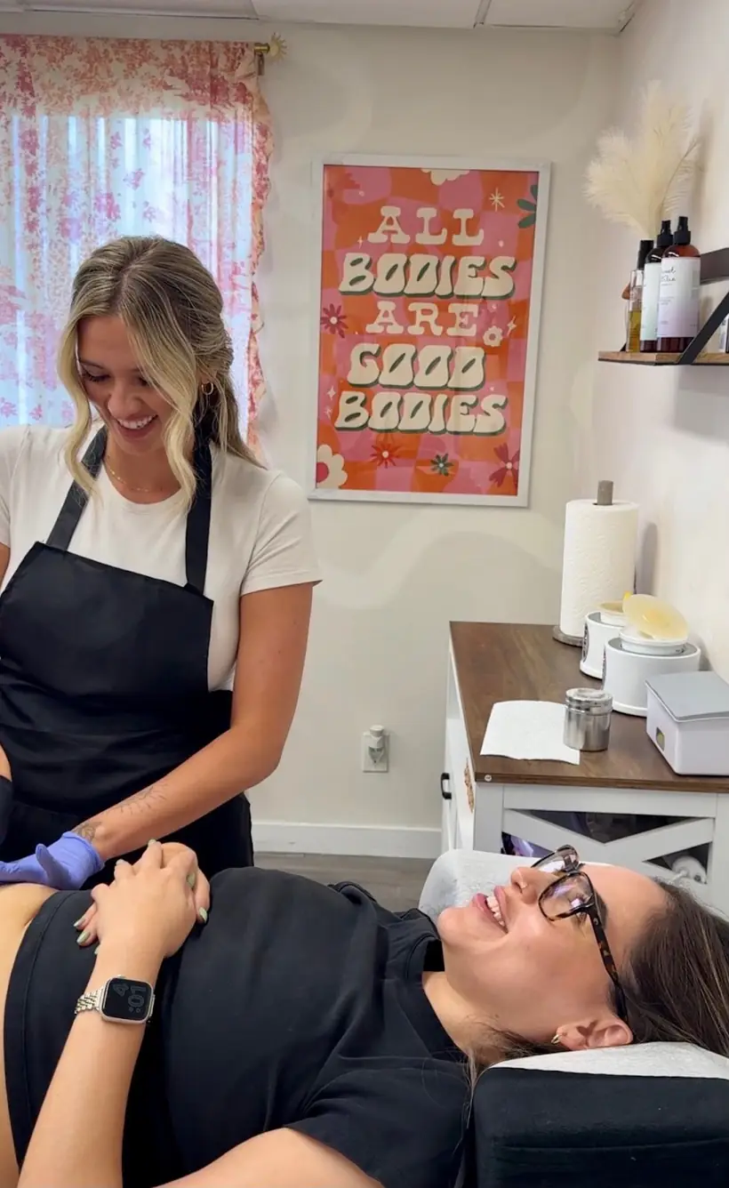 Lindsey sugaring a smiling client at Sugar Bare OC